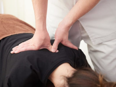 Woman getting her back adjusted by a chiropractor